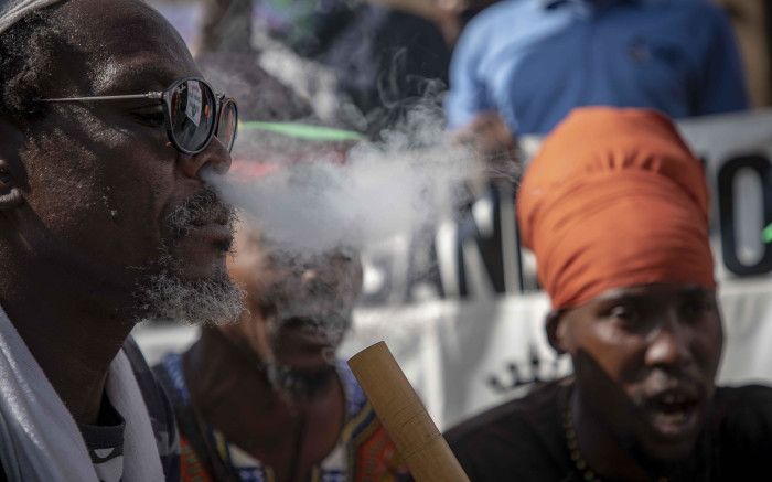 Rastafarians smoke cannabis outside the South African Constitutional Court before the ruling on the private use marijuana is delivered on 18 September 2018. Picture: Thomas Holder/EWN