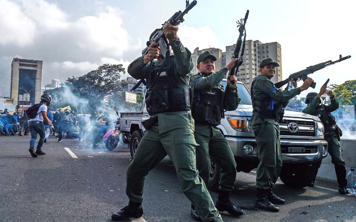 Members of the Bolivarian National Guard who joined Venezuelan opposition leader and self-proclaimed acting president Juan Guaido fire into the air to repel forces loyal to President Nicolas Maduro who arrived to disperse a demonstration near La Carlota military base in Caracas on 30 April 2019. Picture: AFP