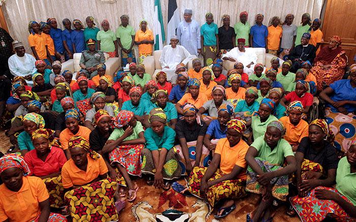 A handout picture released by the PGDBA&HND Mass Communication/Sunday Aghaeze shows Nigeria's President Muhammadu Buhari (C) sitting among the 82 rescued Chibok girls during a reception ceremony at the Presidential Villa in Abuja, on 7 May 2017. Picture: AFP