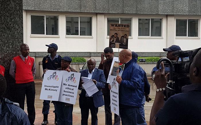 Demonstrators hold up posters during a protest against McKinsey over 'irregular payments' involving Eskom and Trillian on 5 October 2017. Picture: Supplied.