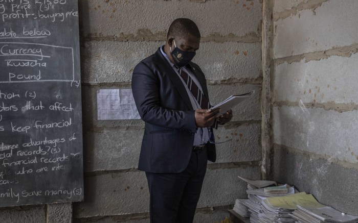 Gauteng Education MEC Panyaza Lesufi inspects the books in one of the classrooms. 