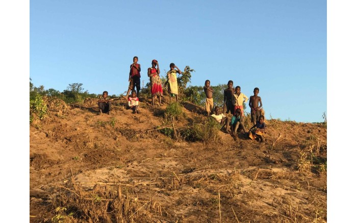 People from villages along the Buzi River wave down the relief boats.