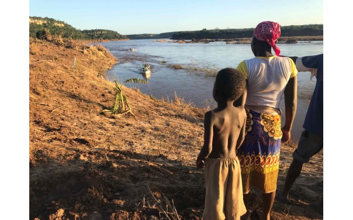 A child and his mother wait for the relief boats to arrive on the banks of the Buzi River.