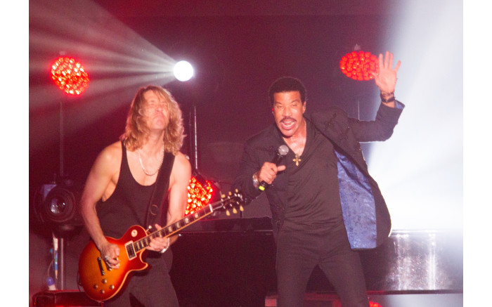 Lionel Richie rocking on stage with his guitarist.