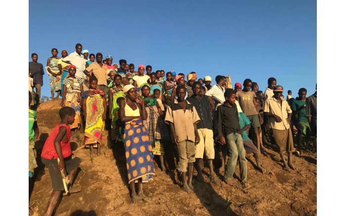 People from villages along the Buzi River wait for relief boats .