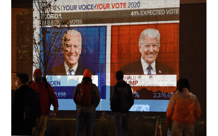 People watch a big screen displaying the live election results on 3 November 2020.