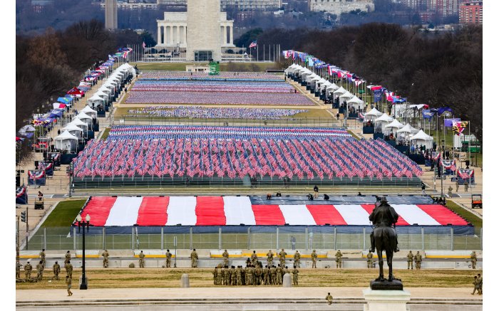 Members of the National Guard look on as American flags decorate the 'Field of Flags' at the National Mall ahead of the inauguration.