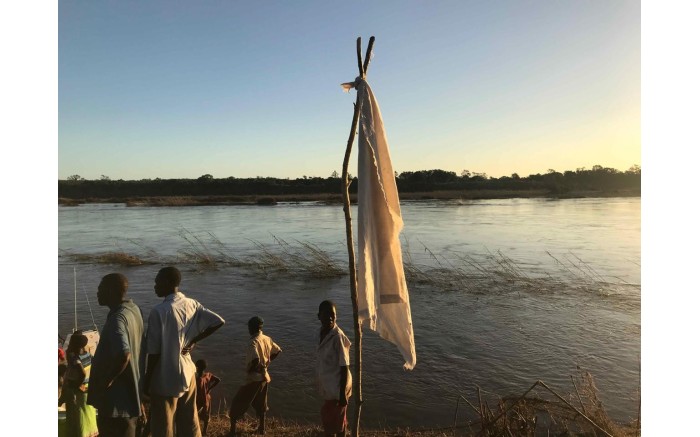 Villagers along the Buzi River set up a white flag to mark their location for the relief boats.