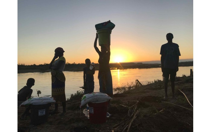 Villagers make their way back home after receiving food and water from relief workers.