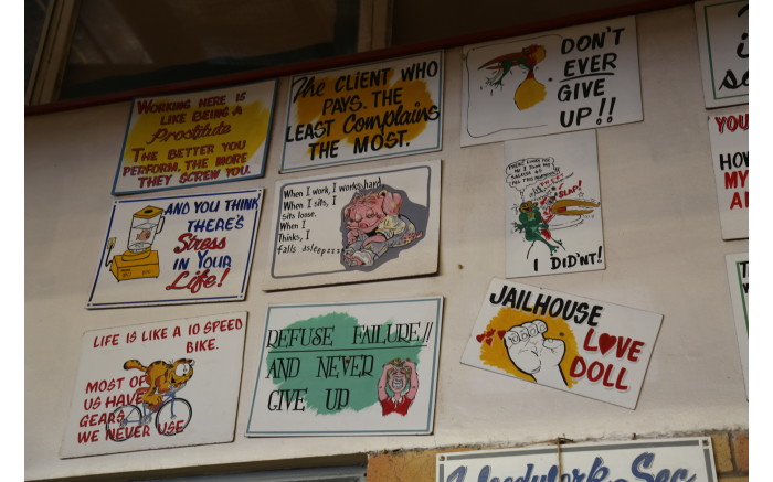 Pictures and signs in the furniture workshop of the Kgosi Mampuru II Correctional Centre.